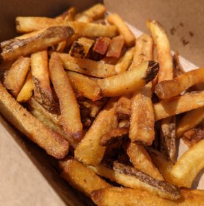 Fries in a brown takeout container from Scratch Box Gastro Truck