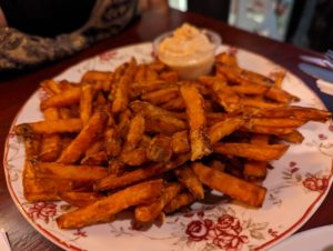 A plate of sweet potato fries with a spicy aioli - Pubwells