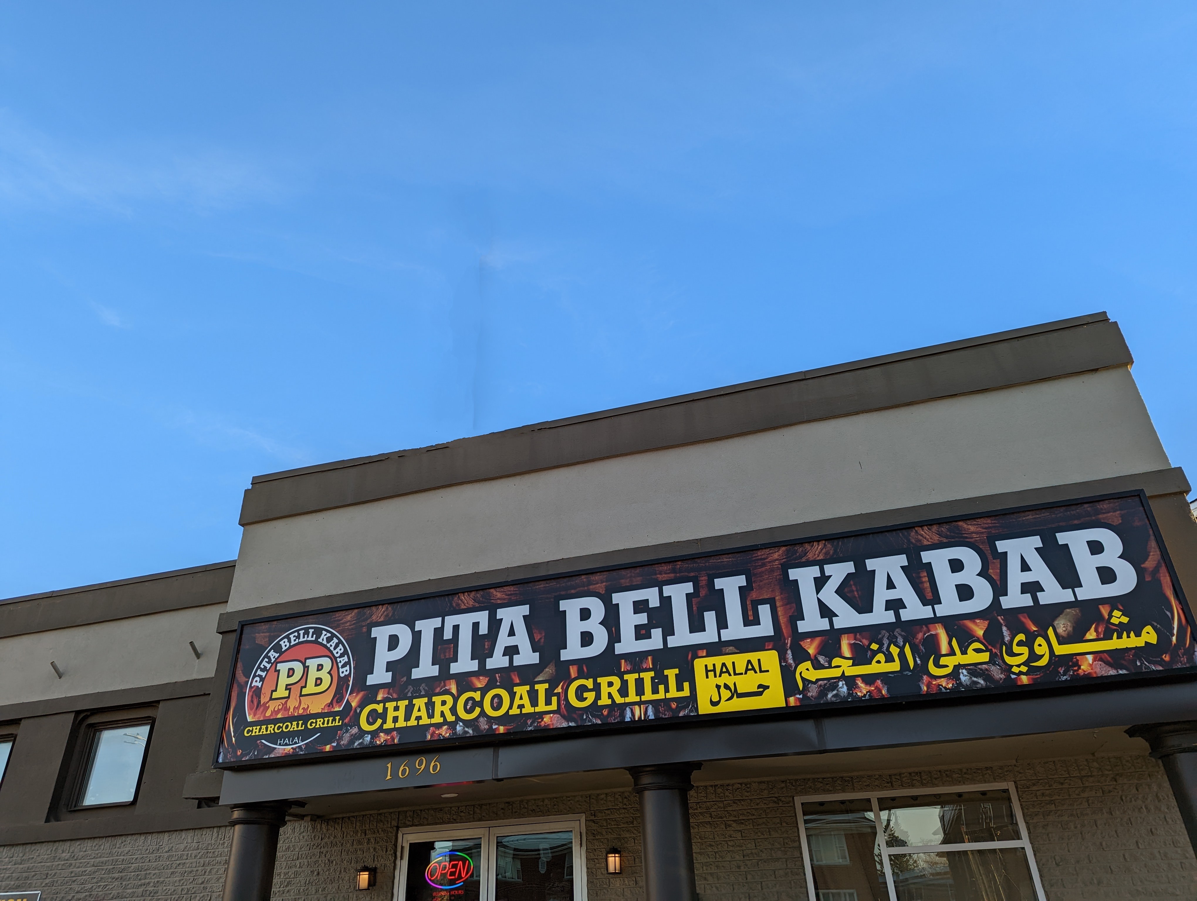 Exterior of Pita Bell Kabab restaurant wit lot of blue sky above it